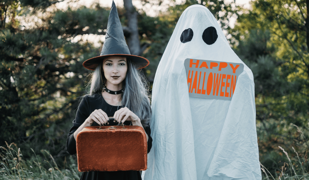 A couple dresses in DIY Halloween costumes in the theme of a witch and a ghost.