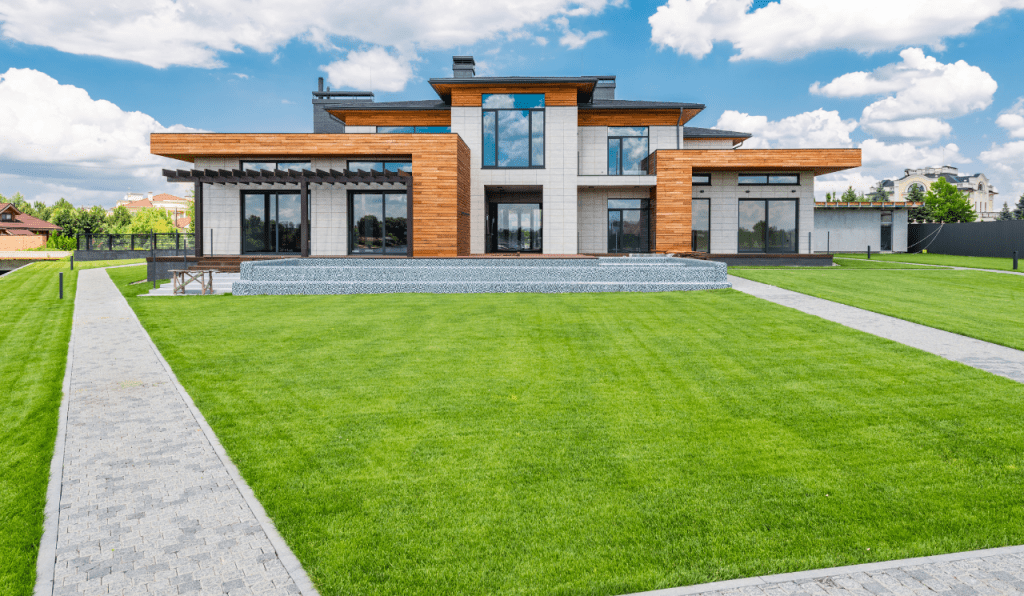 A symmetrical garden path in the front garden, leading towards a modern house.